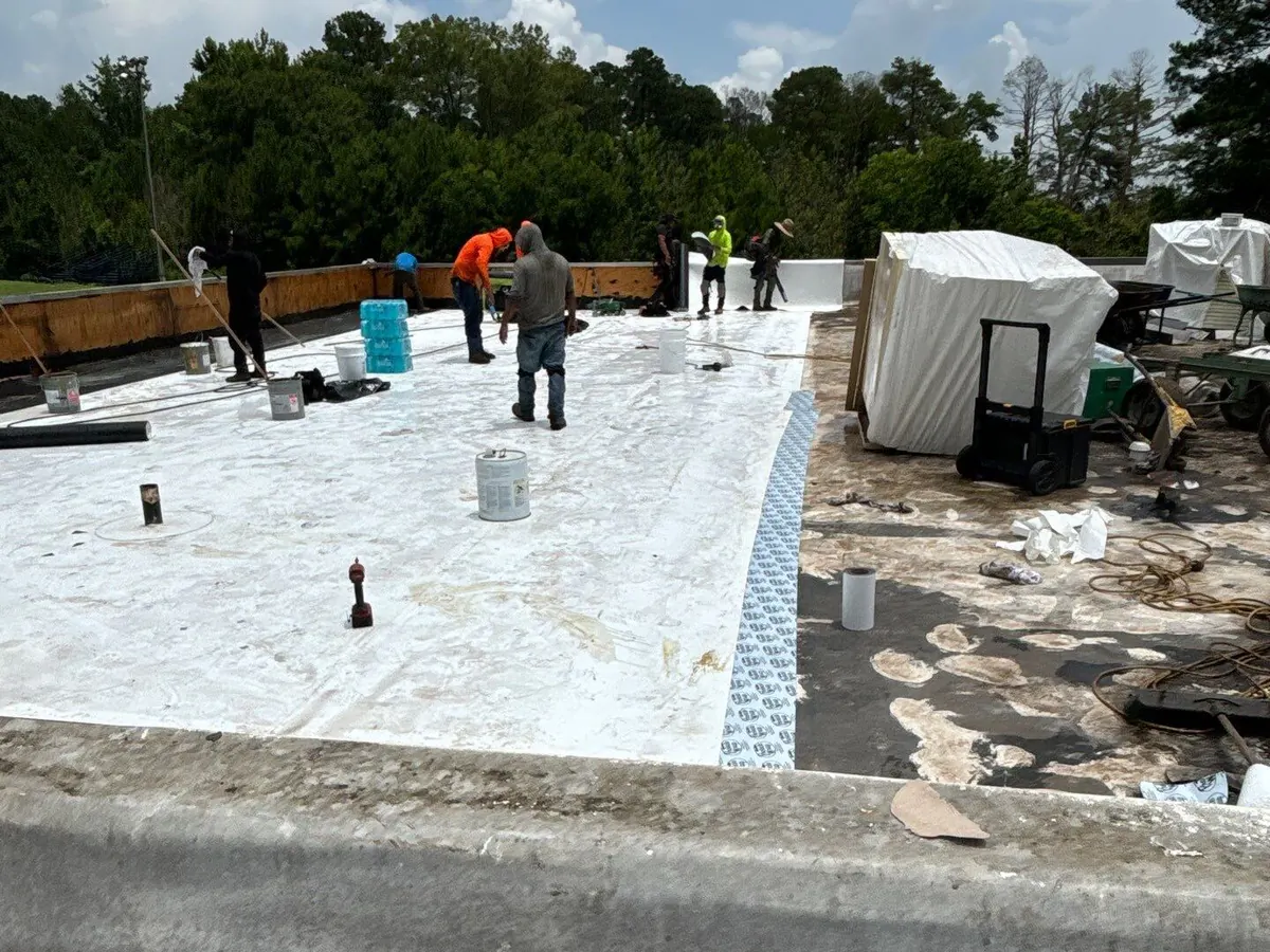 Dickerson crew installing white single-ply membrane on a commercial deck